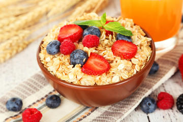 Oatmeal with berries on brown wooden background