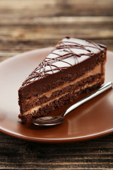 Dark chocolate cake on brown wooden background