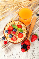 Oatmeal with berries on white wooden background