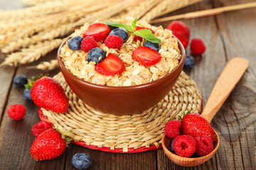 Oatmeal with berries on brown wooden background