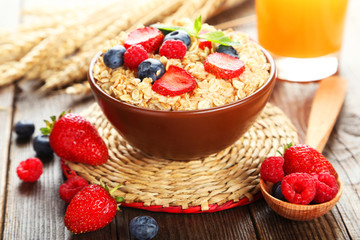 Oatmeal with berries on brown wooden background