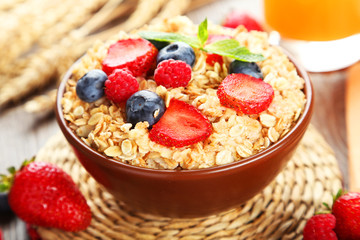 Oatmeal with berries on brown wooden background