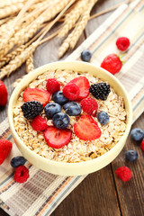 Oatmeal with berries on brown wooden background