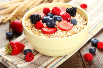 Oatmeal with berries on brown wooden background