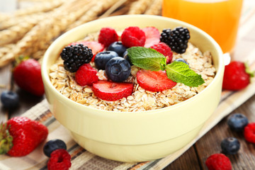 Oatmeal with berries on brown wooden background