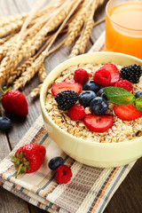 Oatmeal with berries on brown wooden background