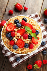 Oatmeal with berries on brown wooden background