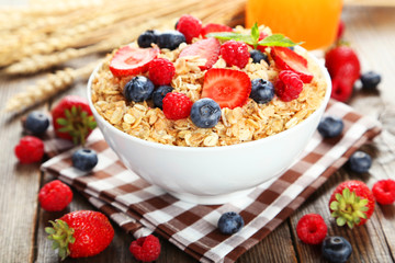 Oatmeal with berries on brown wooden background