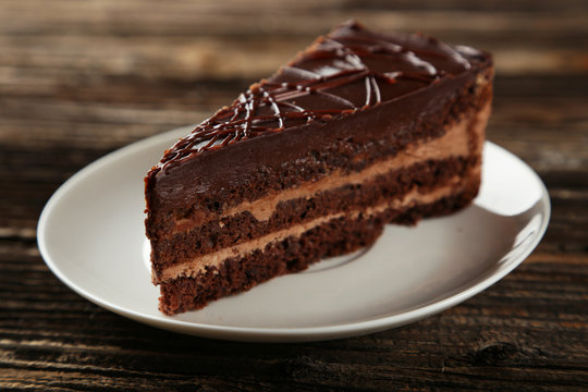 Dark chocolate cake on brown wooden background