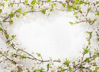 Blooming (flowering) tree branches as round frame on white painted wood captured from above. Spring blossom - background layout with free text space.