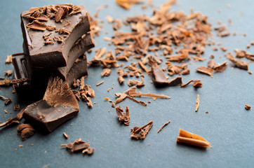 Broken chocolate bar, chips and powder. Shallow depth of field.