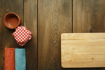 Kitchen plank, bowl, kitchen towel and jar on picnic table