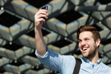 Happy young modern man taking selfie