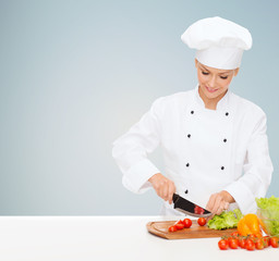 smiling female chef chopping vegetables