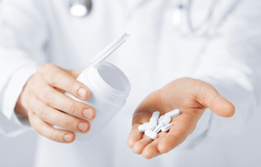 doctor hands holding white pack and pills