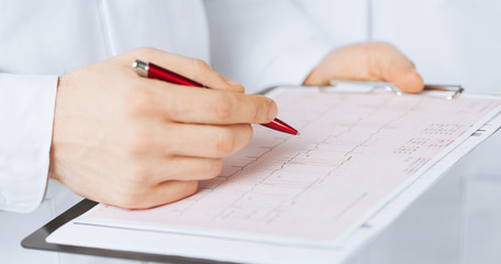 male doctor hands holding cardiogram