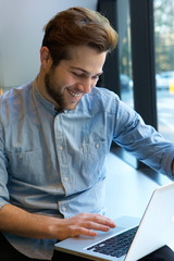 Cheerful man using laptop