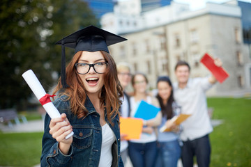 group of smiling students with diploma and folders