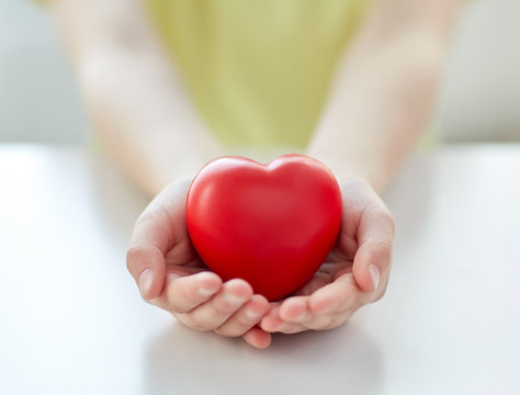 close up of child hands holding red heart