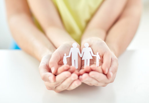 close up of woman and girl hands with paper family