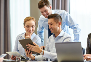 smiling business people with tablet pc in office
