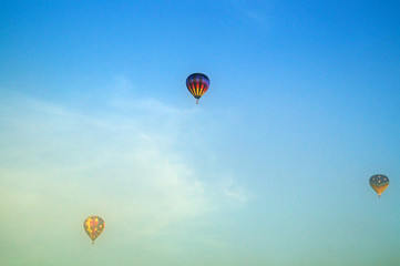 three hot air balloons flying above morning fog