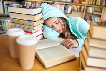 student or woman with books sleeping in library