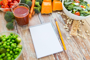 close up of ripe vegetables and notebook on table