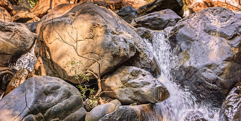 Relaxing small waterfall with trees and rocks in mountain