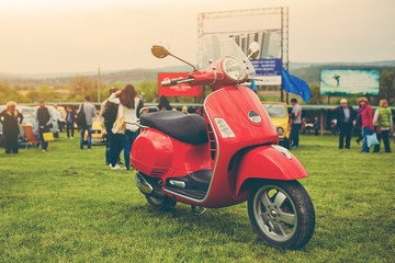 Red retro scooter on grass