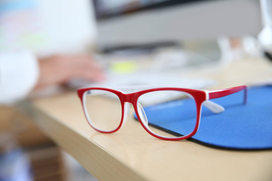 Closeup of red eyeglasses on business desk