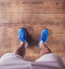 Legs of a runner on a wooden floor background