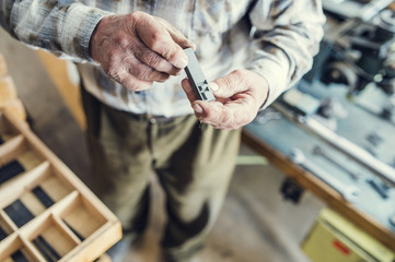 Senior man holding a letter that is used for engraving