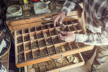 Senior man holding a letter that is used for engraving