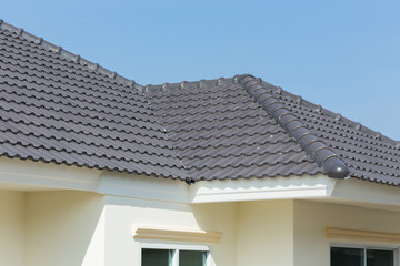 black roof tiles on house with blue sky - obrazy, fototapety, plakaty