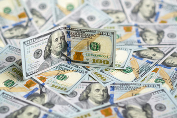 hundred dollar bill on  pile of money