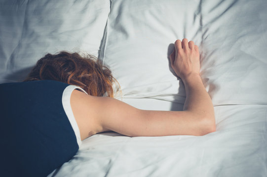 Woman wearing a dress sleeping on bed