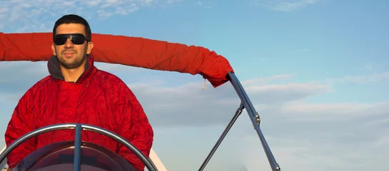 Poster Im Rahmen Kapitän auf einem Schlauchboot, Mann, der ein aufblasbares Motorboot fährt © darioracane