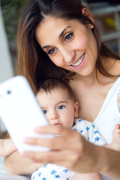 Beautiful mother and baby taking a selfie at home.