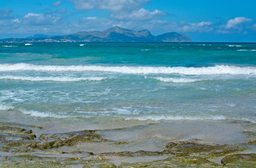 Sunny beach with waves in Can Picafort, Mallorca