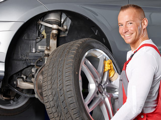 Motor mechanic changes a tyre