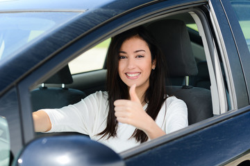 happy beautiful young brunette woman driving her car