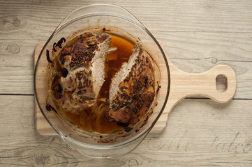 pork meat in roaster with onion cumin and garlic on wooden table