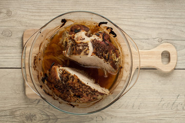 pork meat in roaster with onion cumin and garlic on wooden table