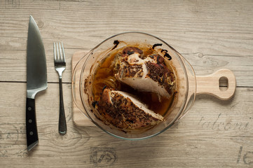 pork meat in roaster with onion cumin and garlic on wooden table