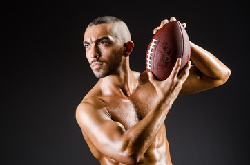 Muscular football player with ball