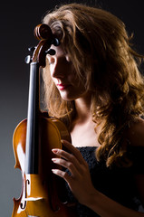 Female musical player against dark background © Elnur