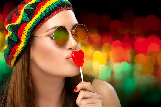 Stylish Party Girl Kissing a Heart Shaped Lollipop