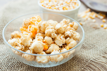 A bowl of popcorn on a wooden table, caramel popcorn