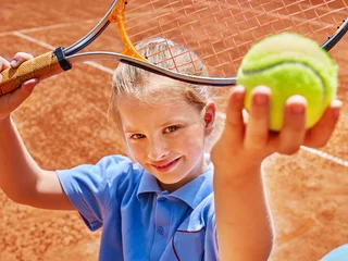 Rolgordijnen Child with racket and ball on  tennis court © Gennadiy Poznyakov